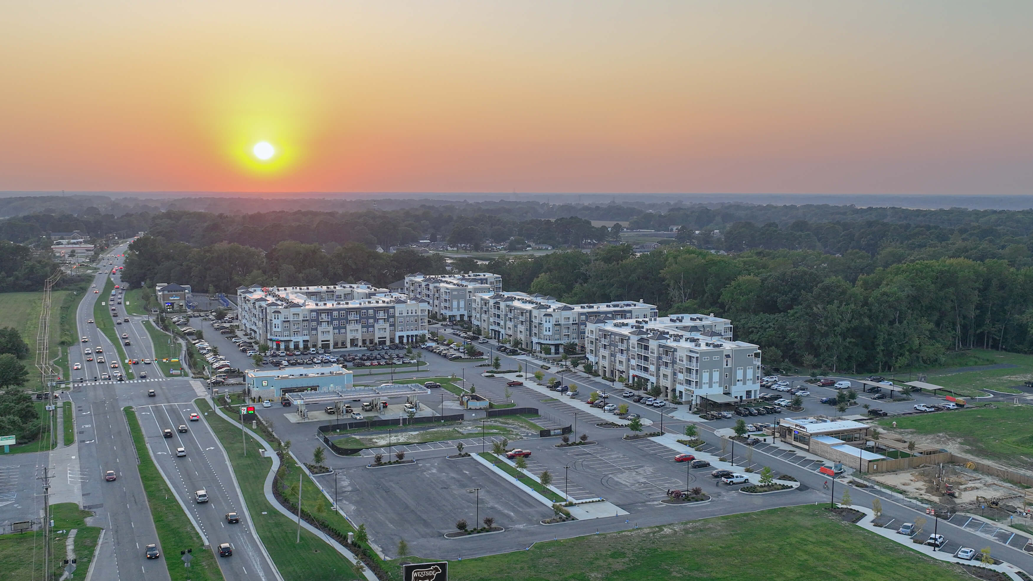 A view from the air showing the Bridgeport North Suffolk mixed-use development in the foreground, sunset in the distance